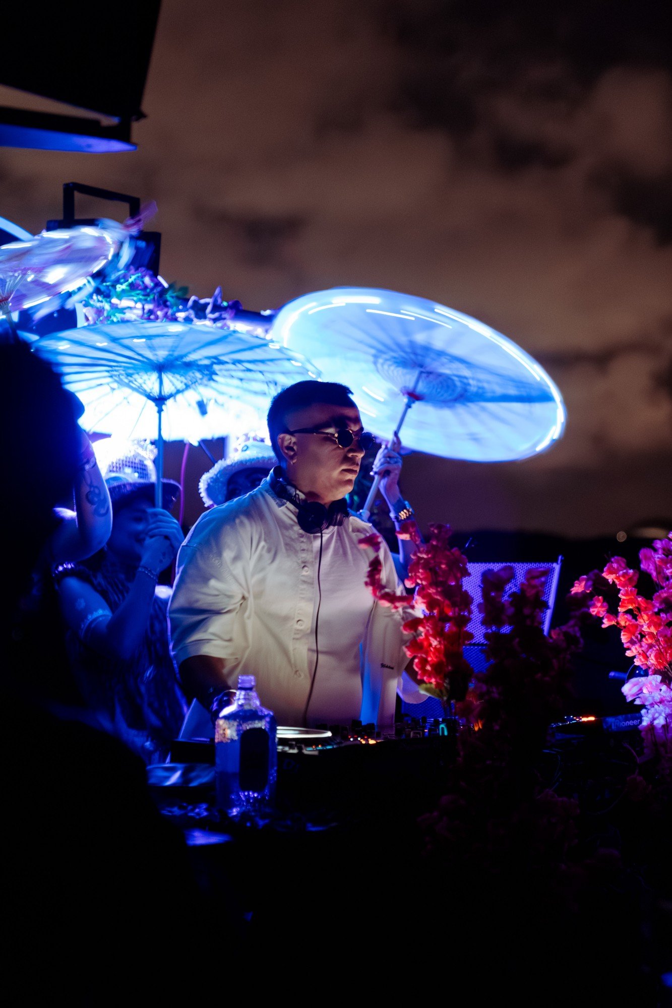 DJ playing an electronic music set under blue lighting at a Spacy Island night in Aruba