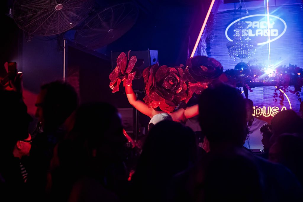 Dancer with a rose headdress on the dance floor at Medusa, Aruba, under the Spacy Island sign